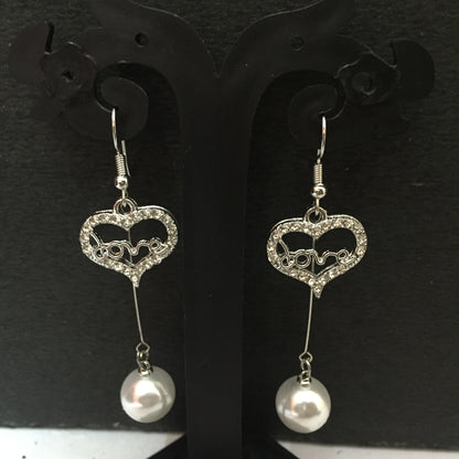 Heart-shaped crystal dangler earrings with ‘love’ design and pearl drop – stylish fashion jewellery